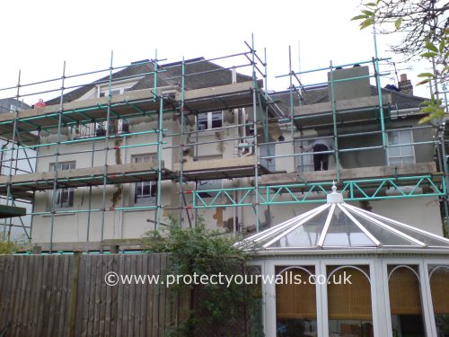 The back of a house during the re-rendering process.