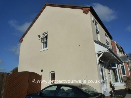 Freshly rendered beige house, side view.
