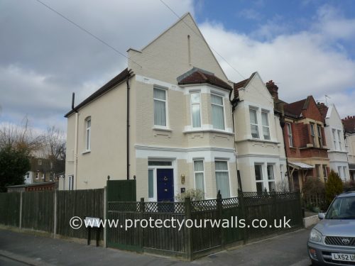 A house with new render and tan paint, front view.