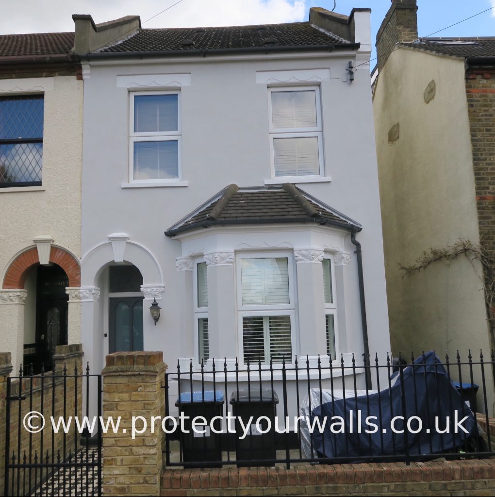 Smoothing out pebbledash on a semi-detached house.